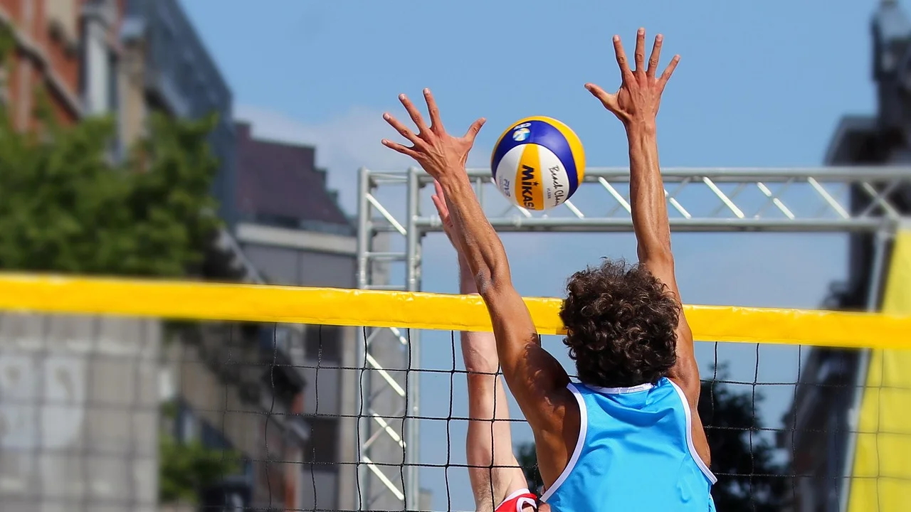 Jogadores treinam manchete e recepção em uma quadra de vôlei.