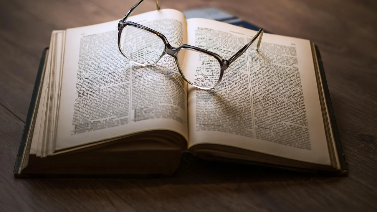Estudante consulta livros e anota referências para um trabalho acadêmico.