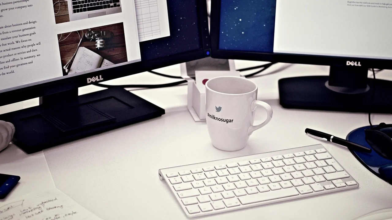 Notebook conectado a dois monitores em uma mesa de trabalho