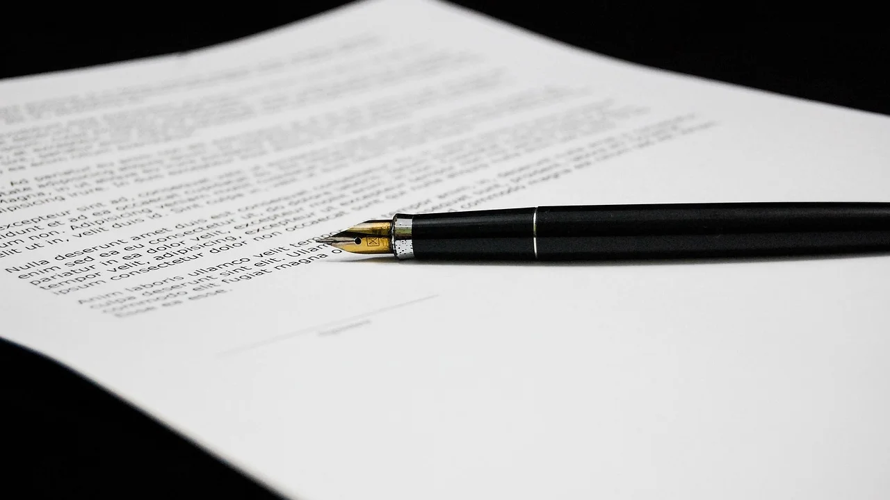 Pessoa revisa páginas de um PDF em notebook.