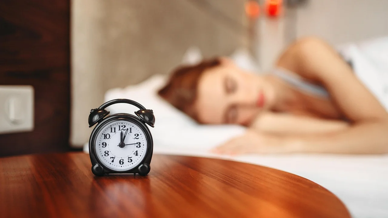 Relógio ao lado da cama reforça a importância de horários consistentes.