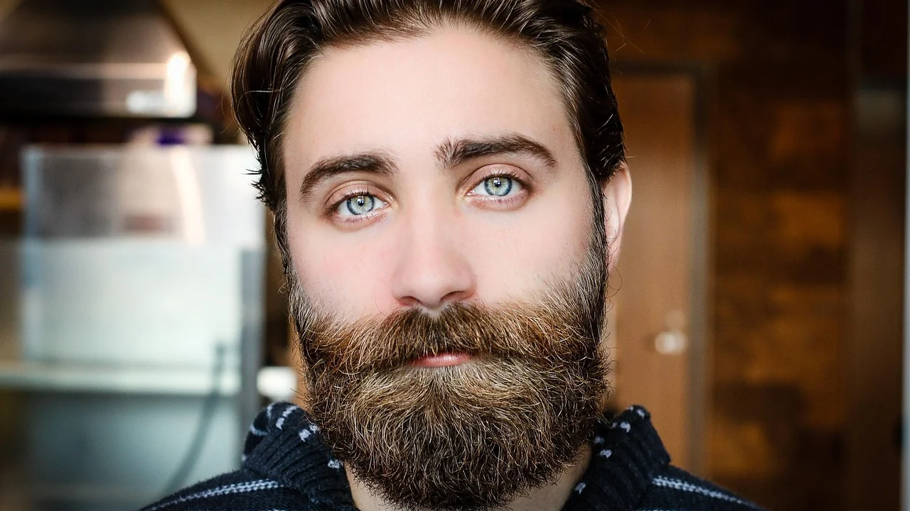 Homem penteando a barba diante do espelho
