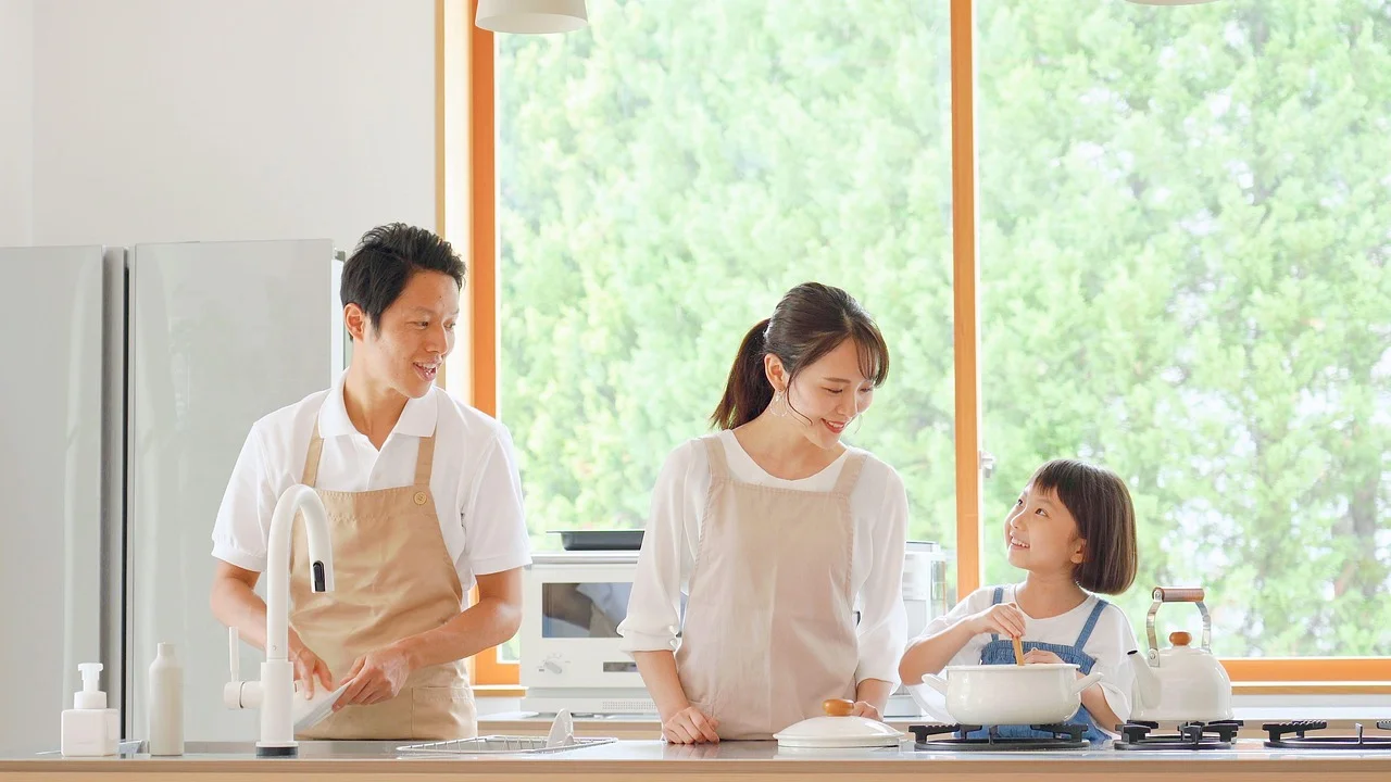 Família organizando tarefas domésticas em um quadro na cozinha.