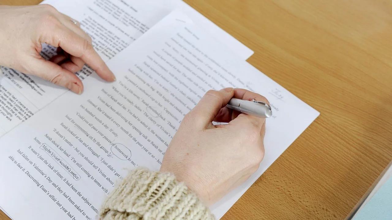 Pessoa revisando um documento PDF em um notebook.