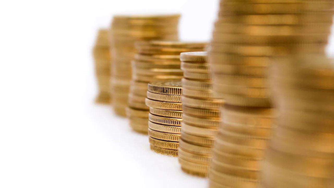 Pessoa compara opções financeiras em uma mesa de trabalho.