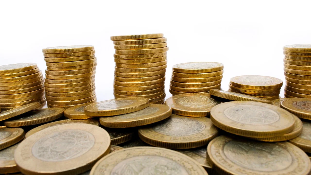 Calculadora, caderno e moedas ajudam no planejamento financeiro.