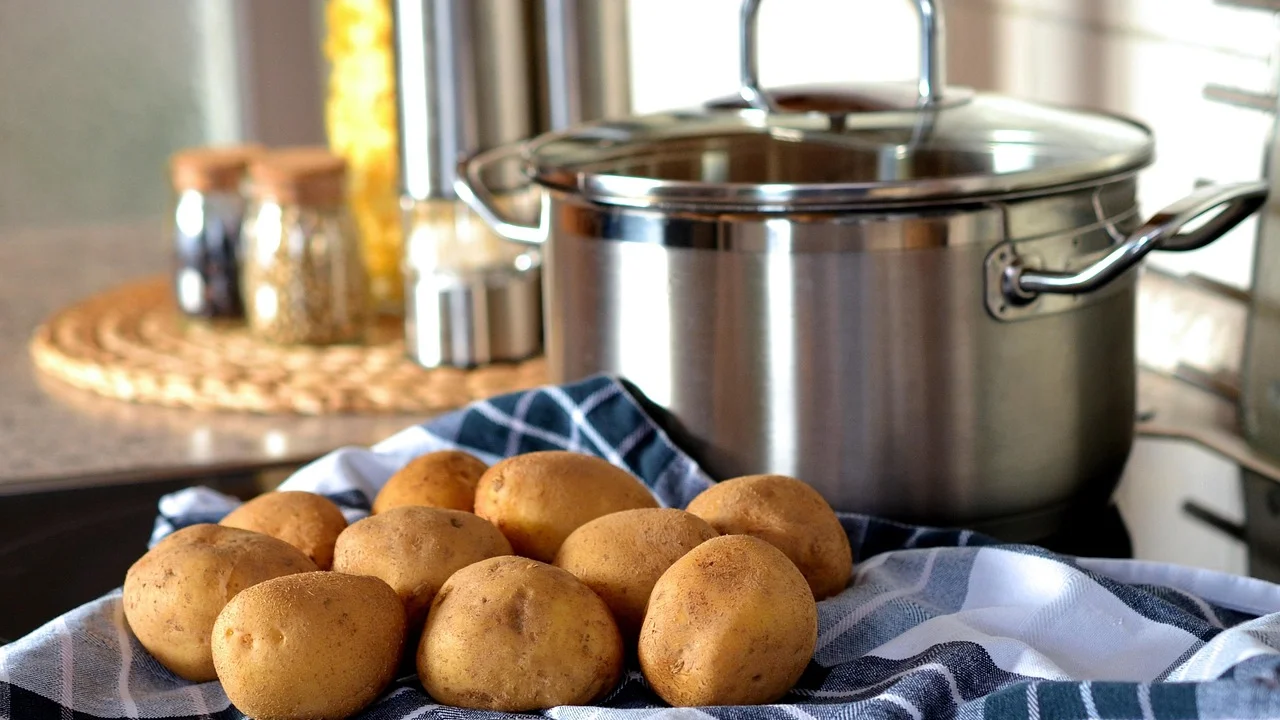 Tampas de vidro e metal apoiadas ao lado de utensílios de cozinha.