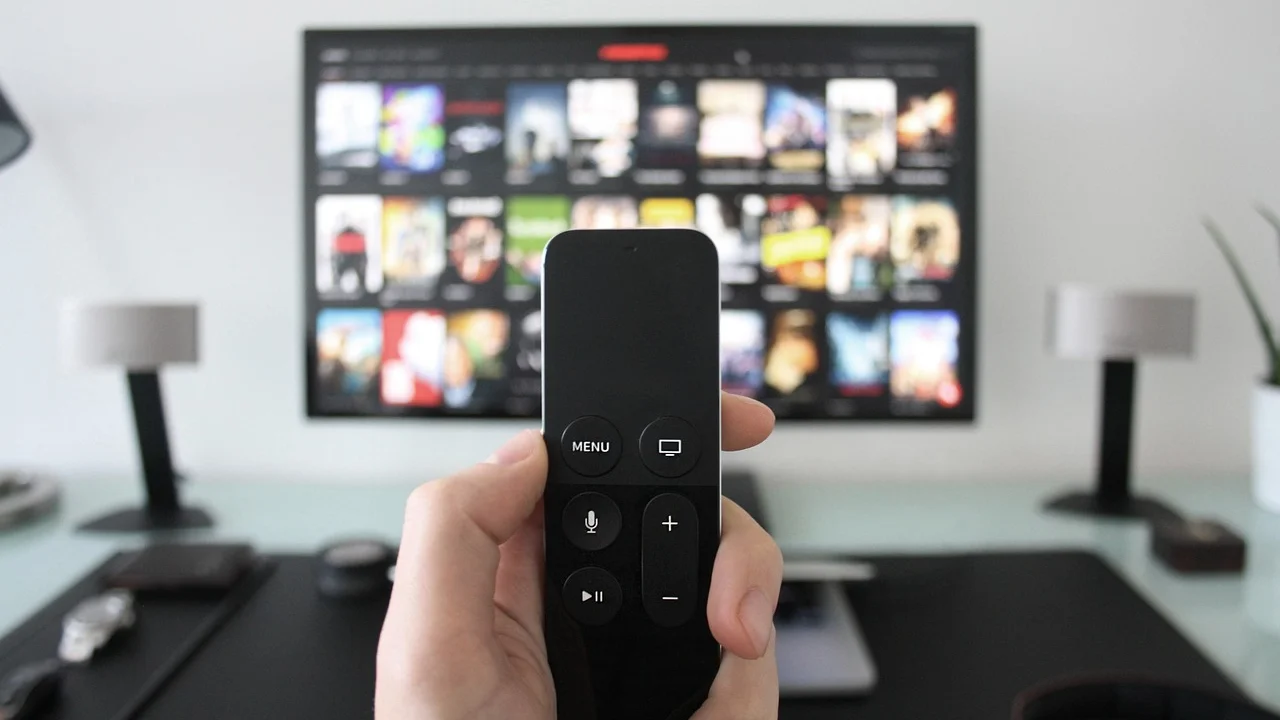 Pessoa comparando plataformas de vídeo na televisão