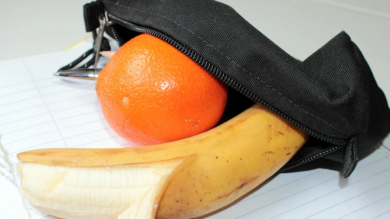 Lancheira com frutas, sanduíche e garrafa de água para o intervalo escolar.