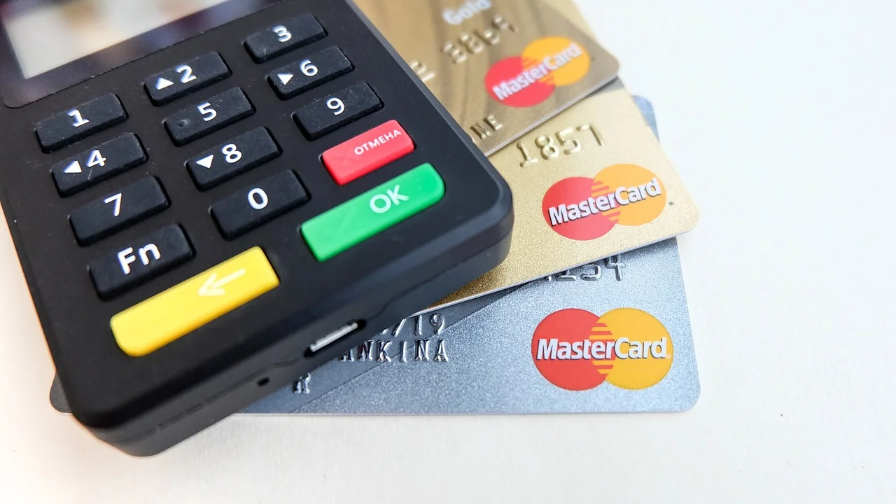 Cartão bancário e celular usados para organizar pagamentos.