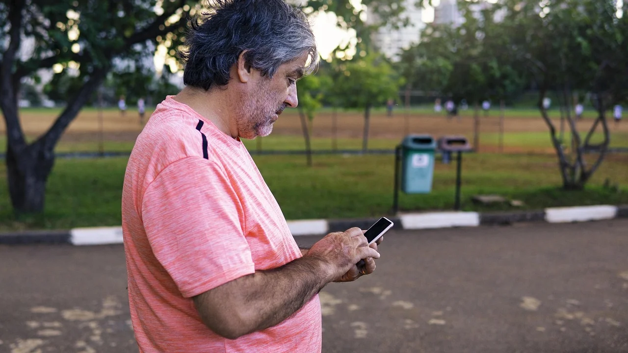 Pessoa idosa usando o celular para acessar serviços digitais.