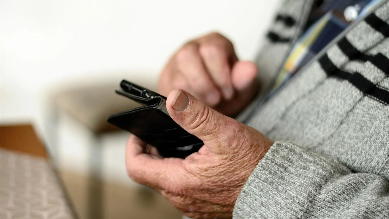 Família auxilia idoso a usar recursos digitais com segurança.