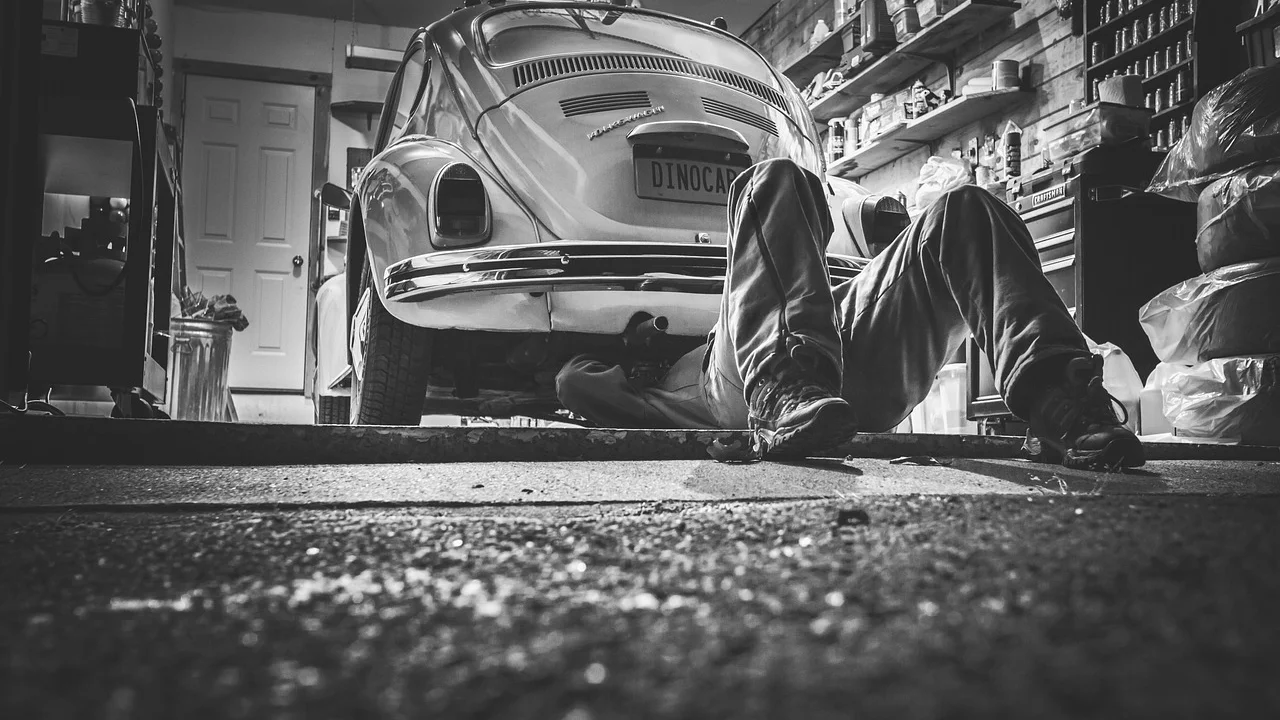 Mecânico inspeciona o sistema de freios de um carro.
