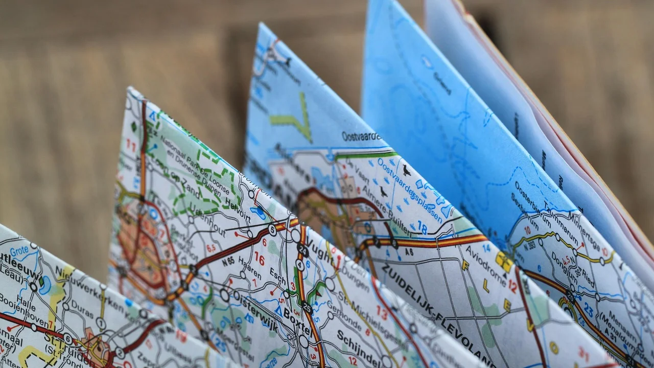 Caderno, passagens e celular usados no planejamento de uma viagem.