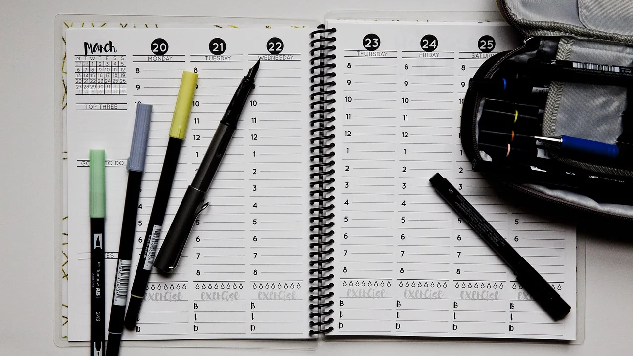 Pessoa organizando tarefas em um calendário de mesa