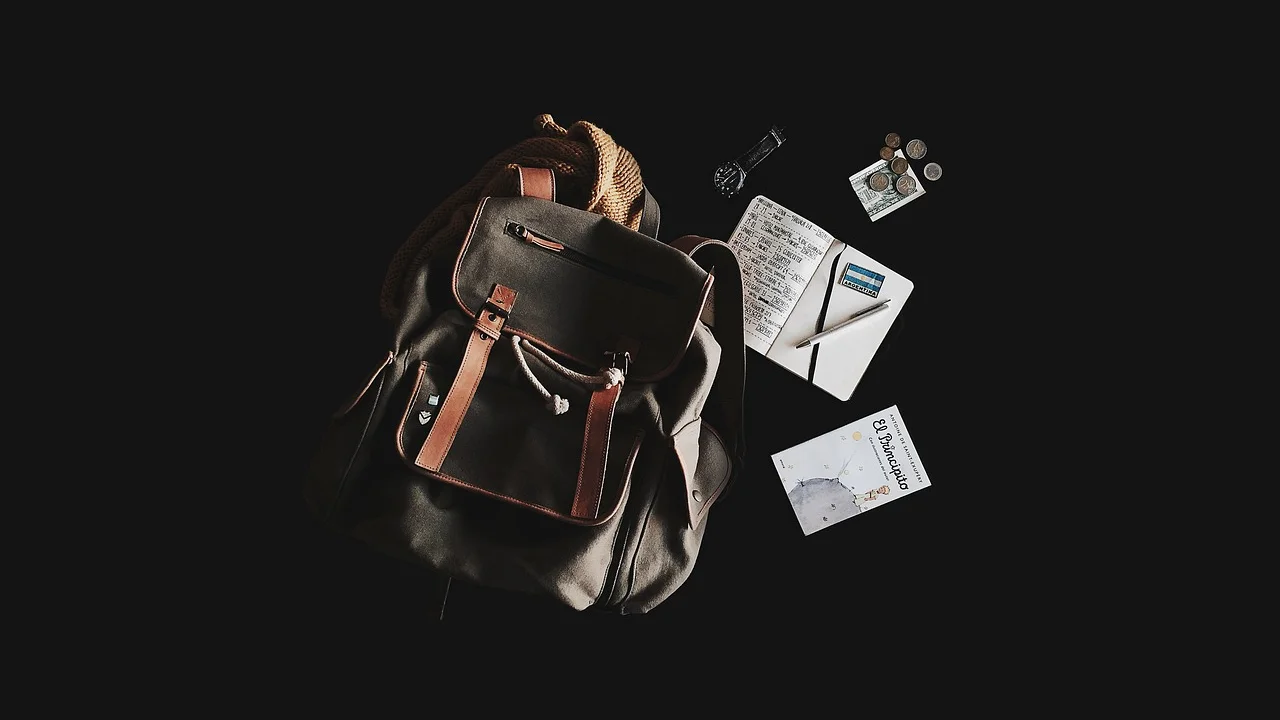 Mala aberta com roupas, documentos e itens essenciais de viagem.