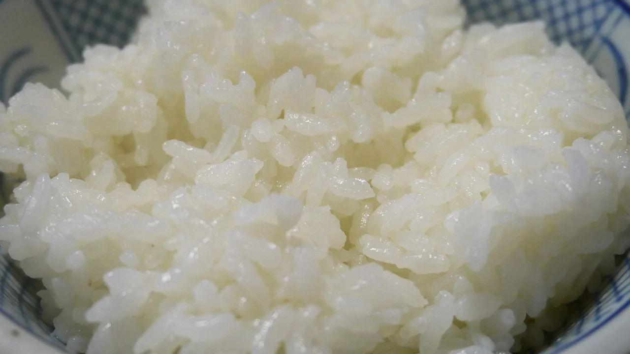 Arroz cozido solto com garfo após o descanso