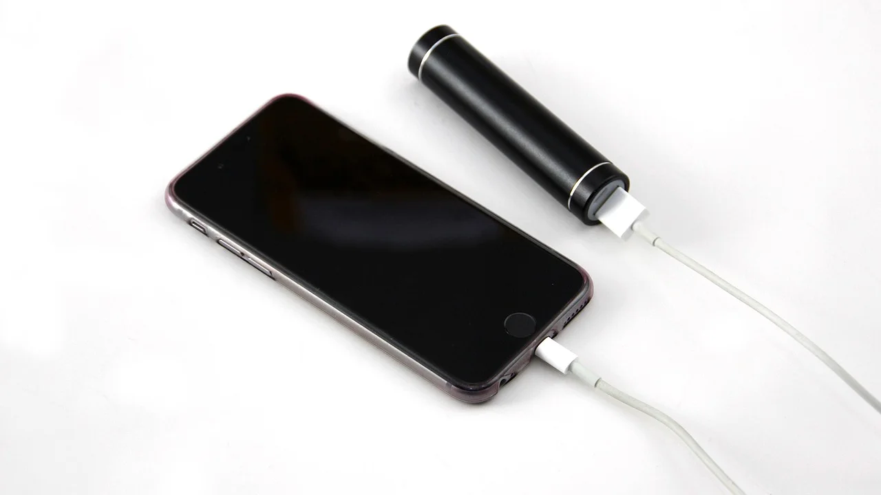 Celular conectado ao carregador sobre uma mesa limpa