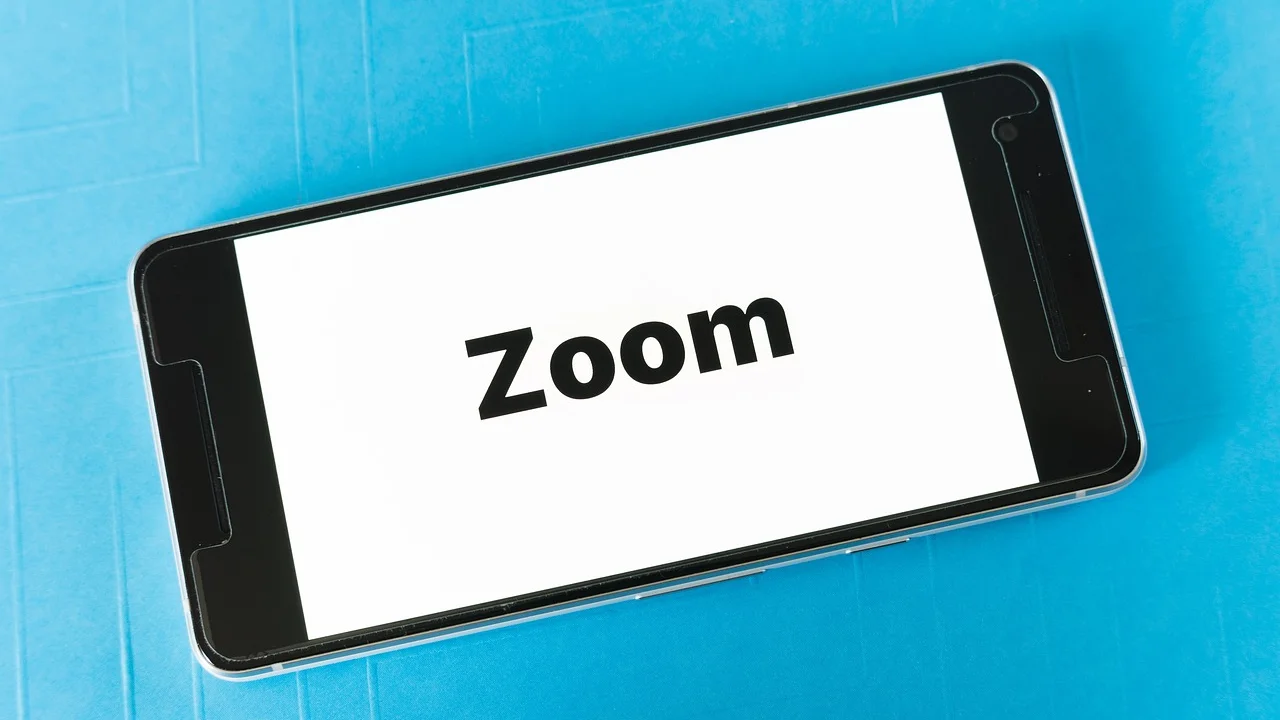Celular apoiado como webcam ao lado de um notebook