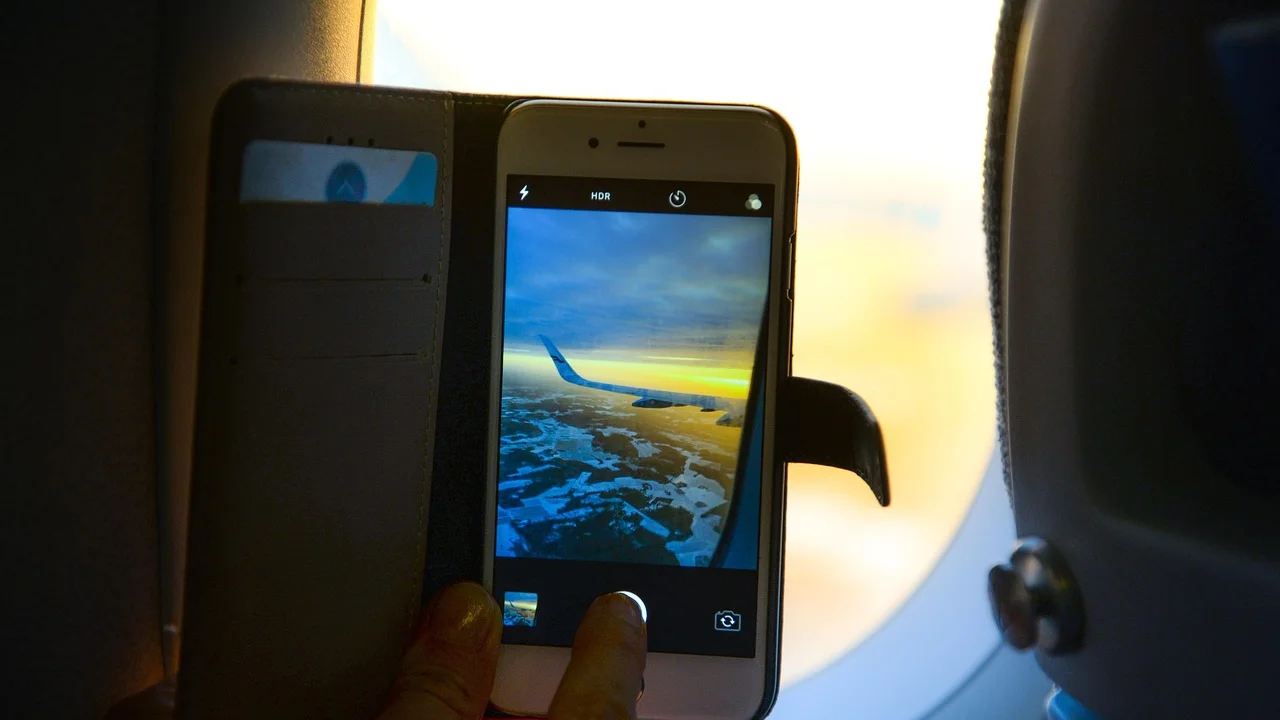 Pessoa usando fones sem fio com o smartphone em modo avião.