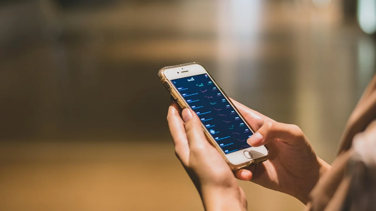 Celular aproximado de uma maquininha para pagamento NFC