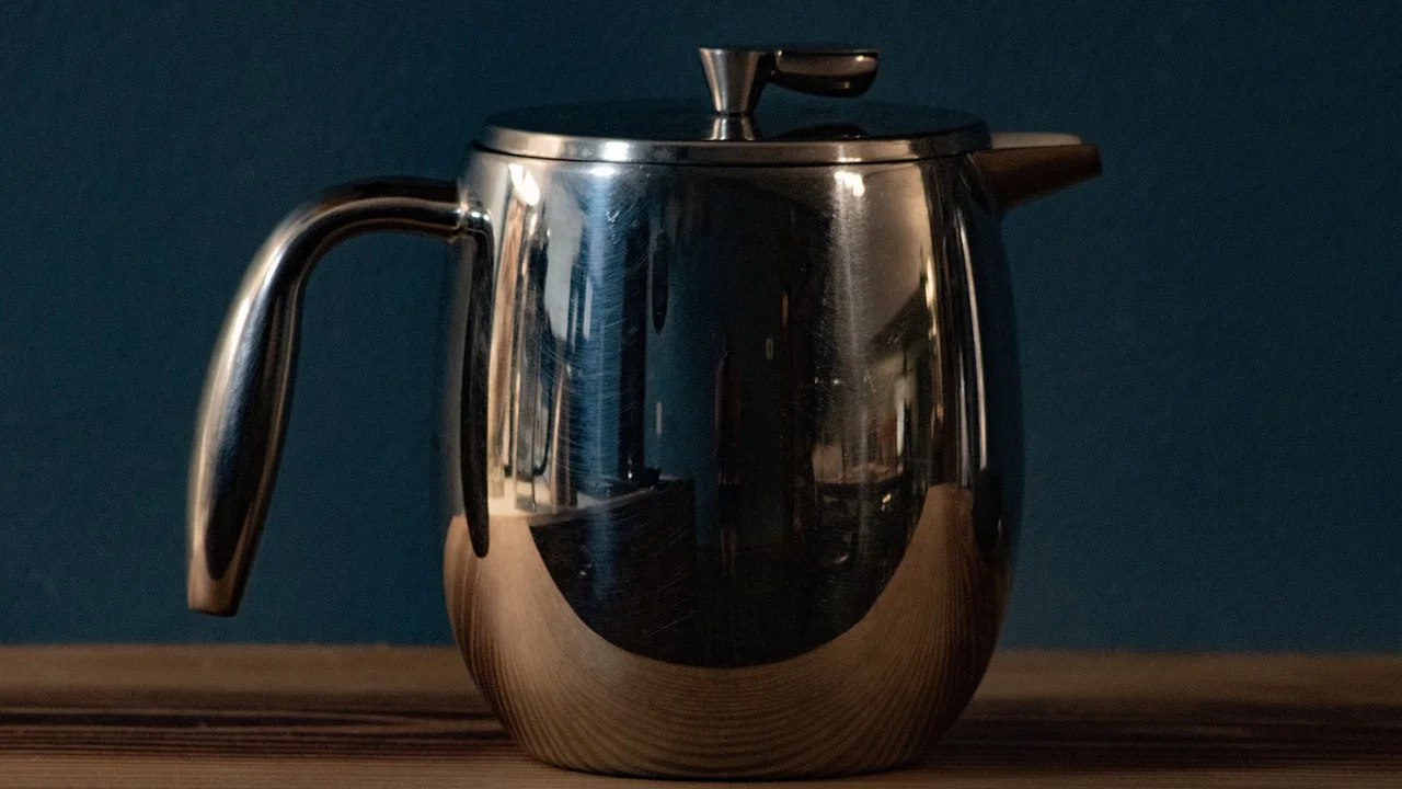 Prensa francesa com café recém-preparado sobre uma bancada